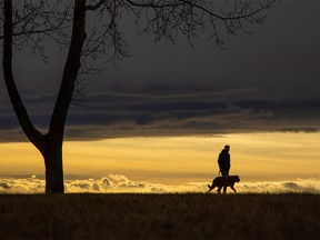 Calgarians walk under a late afternoon chinook arch in North Glenmore Park on Sunday, November 21, 2021.
