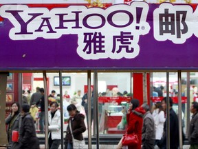 In this file photo taken on Nov. 14, 2007, pedestrians walk past a Yahoo billboard in Beijing.