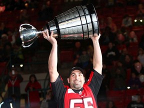 The Calgary Stampeders’ Randy Chevrier greets the crowed with the Grey Cup during the 47th annual Calgary Firefighters Toy Association Christmas Party at the Stampede Corral for 4,000 deserving children on Dec. 14, 2014.