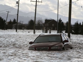 A car is submerged in flood waters on a farm after rainstorms caused flooding and landslides in Abbotsford.