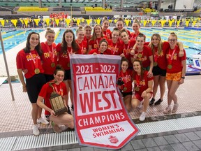 The University of Calgary Dinos women’s swim team celebrates after winning the Canada West championship at the Kinsmen Sports Centre in Edmonton on Sunday, Nov. 28, 2021.