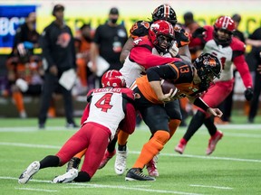 B.C. Lions quarterback Michael Reilly is sacked by the Calgary Stampeders’ Richard Leonard (4) and Isaac Adeyemi-Berglund, back, at BC Place in Vancouver on Friday, Nov. 12, 2021.