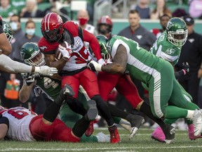 Calgary Stampeders running back Ka’Deem Carey is tackled by several Saskatchewan Roughriders defenders at Mosaic Stadium in Regina on Saturday, Oct. 9, 2021.