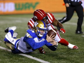 Calgary Stampeders linebacker Jameer Thurman tackles Winnipeg Blue Bombers quarterback Dru Brown to cause a fumble at McMahon Stadium in Calgary on Saturday, Nov. 20, 2021.