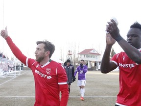 Dejected Cavalry FC players Oliver Minatel and Karifa Yao salute the fans as they leave the field after the 2-1 loss to Pacific FC in extra time during CPL semifinal action on Saturday at ATCO Field at Spruce Meadows in Calgary.