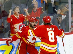 Flames defenceman Oliver Kylington celebrates a recent goal with teammate Chris Tanev at the Scotiabank Saddledome in Calgary.