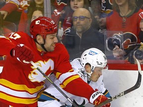 Calgary Flames forward Milan Lucic battles the San Jose Sharks' Rudolfs Balcers during first-period NHL action at the Scotiabank Saddledome on Tuesday.