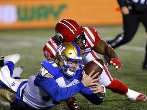 The Stampeders' Jameer Thurman tackles Winnipeg Blue Bombers QB Dru Brown to cause a fumble in first-half CFL action at McMahon Stadium in Calgary on Saturday night.