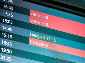 A flight information screen at Calgary International Airport (YYC) shows multiple cancelled flights on Monday, December 27, 2021.
