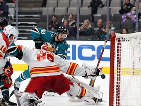 Sharks forward Tomas Hertl scores his second of three goals on the night as Flames goalie Dan Vladar reaches for the puck at SAP Center in San Jose on Tuesday night. The Sharks won 5-3.