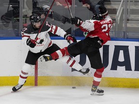 Team Canada's Will Cuylle (27) battles Team Austria's goalie Lukas Moser (29) during second period IIHF World Junior Hockey Championship action in Edmonton on Tuesday, Dec. 28, 2021.