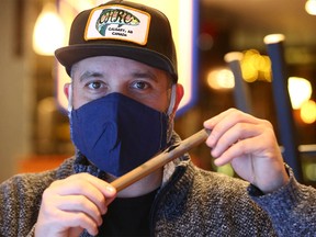 Kevin Warner, Assistant General Manager at the Unicorn Pub on Stephen Ave in Calgary poses with a piece of pipe that burst on Wednesday, December 29, 2021. A pipe burst at the popular pub during the recent cold snap, forcing the business to close.
