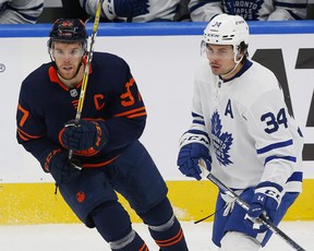 Edmonton Oilers forward Connor McDavid (left) and Maple Leafs forward Auston Matthews look for a loose puck at Rogers Place in Edmonton.