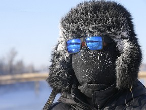 Troy Bilon stays warm walking along the Bow River at Edworthy Park in Calgary on Monday, December 27, 2021.