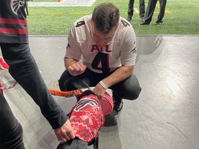 Rob McLeod and Sailor the Touchdown Dog prepare before taking the field at Mercedes-Benz Stadium in Atlanta, GA on Dec. 5, 2021.
