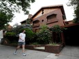 A person walks past a house owned by late Argentine soccer legend Diego Armando Maradona, which will be auctioned, among other things, in Buenos Aires, Tuesday, Dec. 14, 2021.