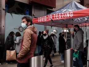 Groups of people line up to get tested for COVID-19 in New York City's Times Square, Sunday, Dec. 5, 2021.