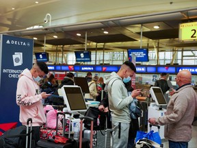 Passengers line up at John F. Kennedy International Airport after airlines announced numerous flights were canceled during the spread of the Omicron coronavirus variant on Christmas Eve in Queens, New York City, Dec. 24, 2021.