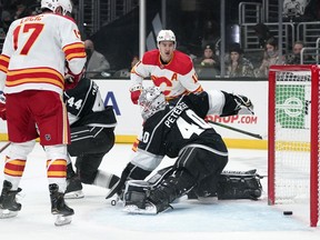 Los Angeles Kings goaltender Cal Petersen is scored on by Calgary Flames defecseman Noah Hanifin, not seen, as left winger Milan Lucic, left, and centre Mikael Backlund watch at Staples Center in Los Angeles on Thursday, Dec. 2, 2021.