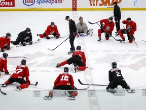 Players stretch as head coach Dave Cameron gives instruction during a practice at the Canadian World Junior Hockey Championship selection camp at WinSport’s Markin MacPhail Centre in Calgary on Thursday, Dec. 9, 2021.
