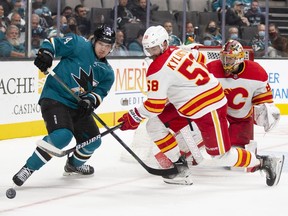The San Jose Sharks’ Alexander Barabanov and Calgary Flames’ Oliver Kylington battle for the puck in front of the Calgary goal at SAP Center at San Jose on Tuesday, Dec. 7, 2021.