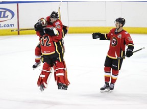 Stockton Heat goaltender Dustin Wolf and leading scorer Jakob Pelletier celebrate a recent shootout victory over the Bakersfield Condors as Glenn Gawdin, right, arrives to join the post-game party.
