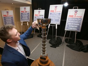 Jesse Hale, GM of the Mac's U18AAA hockey tournament, polishes the winner's trophy on Wednesday.