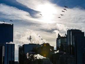 A flock of Canadian geese fly above the Calgary skyline on an extremely cold day on Tuesday, January 4, 2022.