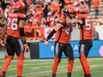 Calgary Stampeders Fraser Sopik, Riley Jones and Dagogo Maxwell celebrate during a game against the Hamilton Tiger-Cats at McMahon Stadium in Calgary on Sept. 14, 2019.