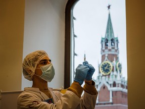 A healthcare worker administers a dose of Russia's Sputnik V Covid-19 vaccine to a patient at a vaccination centre in the GUM State Department store in Moscow on October 21, 2021.