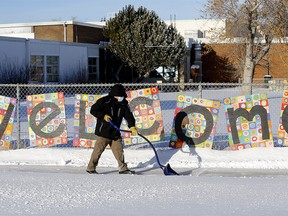 Randy Lai, facility operator of Belvedere Parkway School in Bowness, shovels the snow with still no solid answers when kids will be back to school in Calgary. Photo taken on Tuesday, January 4, 2022.