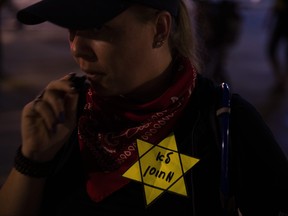A woman wears a yellow Star of David, like the ones Jews were obligated to wear during the Second World War, with Hebrew reads "not vaccinated" during a protest against the Health Ministry's "green pass" system, in Tel Aviv, Israel, Oct. 2, 2021.