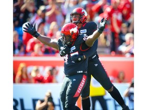 Calgary Stampeders Derek Wiggan and Mike Rose celebrate after a sack on quarterback Trevor Harris of the Edmonton Eskimos during CFL football in Calgary on Monday, September 2, 2019. Al Charest/Postmedia