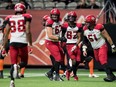 Calgary Stampeders’ Zack Williams (67), Malik Henry (82) and Sean McEwen (51) celebrate Henry’s touchdown against the B.C. Lions at BC Place in Vancouver, on Nov. 12, 2021.