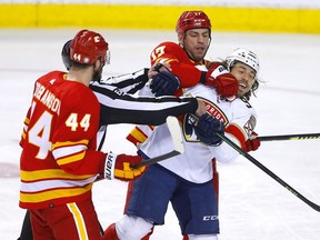 The Calgary Flames’ Milan Lucic battles the Florida Panthers’ Ryan Lomberg at Scotiabank Saddledome in Calgary on Tuesday, Jan. 18, 2022.