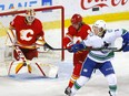 Calgary Flames goaltender Jacob Markstrom makes a save on a shot from the Vancouver Canucks’ Brock Boeser as the Flames’ Juuso Valimaki defends at Scotiabank Saddledome on May 19, 2021.