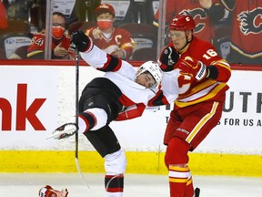 The Calgary Flames’ Nikita Zadorov battles the Ottawa Senators’ Zach Sanford at Scotiabank Saddledome in Calgary on Thursday, Jan. 13, 2022.