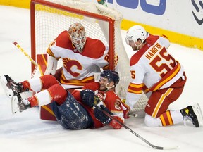 Florida Panthers forward Jonathan Huberdeau reacts after falling to the ice in front of Calgary Flames goaltender Jacob Markstrom and defenceman Noah Hanifin at FLA Live Arena in Sunrise, Fla., on Jan. 4, 2022.