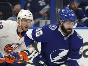 Lightning winger Nikita Kucherov carries the puck with New York Islanders winger Anthony Beauvillier in hot pursuit during Game 1 of the Stanley Cup semifinal series between the two teams in this photo from June 13, 2021, in Tampa.