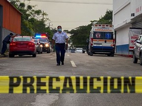 An ambulance remains outside the Playamed hospital, where a wounded person was transported after a shooting in a Hotel in Xcaret, Playa del Carmen, Quintana Roo state, Mexico, on Friday, Jan. 21, 2022.