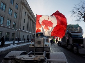 A Canadian flag flies upside down on the back of a truck during a "Freedom Convoy" protesting against COVID-19 vaccine mandates and restrictions in front of Parliament on Friday, Jan. 28, 2022 in Ottawa.