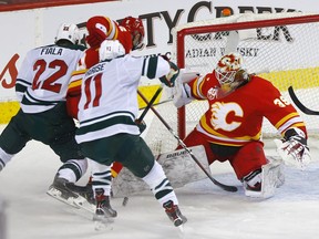 Then-Calgary Flames goaltender Cam Talbot stops then-Minnesota Wild forward Zach Parise  at the Scotiabank Saddledome in Calgary on Jan. 9, 2020.