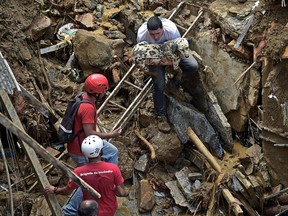 A resident rescues a dog after a mudslide in Petropolis, Brazil on February 16, 2022.