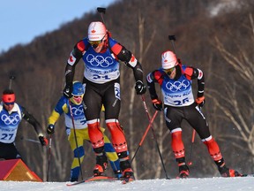 Canada’s Scott Gow (centre) and Christian Gow (right) compete in the biathlon 15-km mass start during the 2022 Winter Olympics at the National Biathlon Centre in Zhangjiakou, China.
