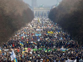 Protesters crowd around the victory column and close to the Brandenburg Gate in Berlin to demonstrate for peace in Ukraine on February 27, 2022. More than 100,000 people turned up at the march in solidarity with Ukraine, police said, with many protesters dressed in the blue and yellow colours of the Ukraine flag.