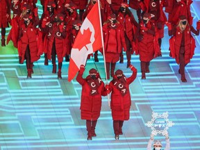 Flag-bearers Charles Hamelin and Marie-Philip Poulin lead Team Canada into the opening ceremony of the Beijing 2022 Winter Olympics on Friday, Feb. 4, 2022.