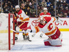 Calgary Flames goaltender Dan Vladar reaches for a shot taken by Vancouver Canucks forward Conor Garland. The puck would elude Vladar, and the Canucks would go on to post a 7-1 victory at Rogers Arena.