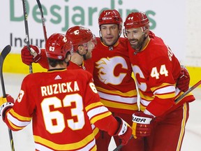 Calgary Flames defenceman Erik Gudbranson (right) celebrates with teammates after scoring a goal against the  Columbus Blue Jackets at Scotiabank Saddledome in Calgary on Feb. 15, 2022.