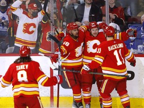 The Calgary Flames’ Andrew Mangiapane (second from right) celebrates with teammates after scoring against the Toronto Maple Leafs at Scotiabank Saddledome in Calgary on Thursday, Feb, 10, 2022.