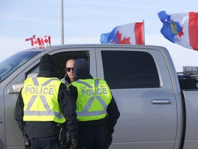 Authorities deal with a new roadblock on Highway 4 and 501 outside of Milk River heading towards the Coutts border crossing but protesters where letting trucks through on one lane on Thursday, February 3, 2022.